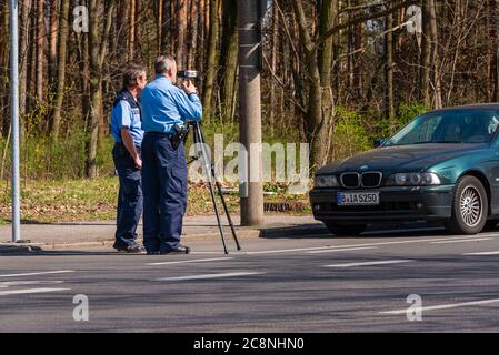 Polizeibeamte kontrollieren die Geschwindigkeit mit einer Laserpistole, Geschwindigkeitskontrolle, zwei Polizisten machen eine Geschwindigkeitskontrolle Stockfoto