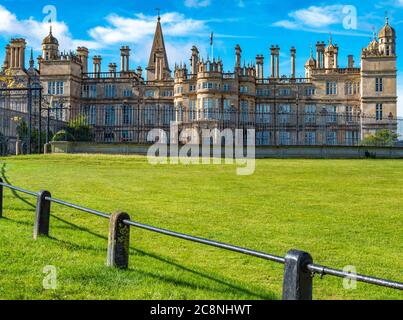 Vor dem historischen Burghley House, in der frühen Morgensonne, mit Geländern um das Gras im Vordergrund. Stamford, Lincolnshire, England, Großbritannien. Stockfoto