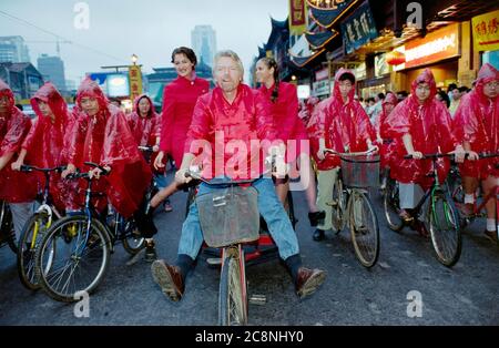 Sir Richard Branson, Gründer der Virgin Group, einschließlich Virgin Atlantic Airlines, radeln durch die Straßen von Shanghai und feiern im Juli 1999 den Erstflug der Fluggesellschaft von Heathrow in die chinesische Stadt. Stockfoto