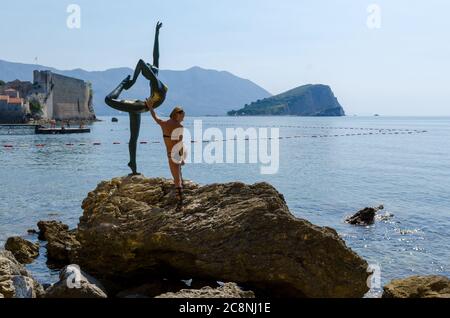 Tourist posiert für ein Foto in der Nähe der Statue Stockfoto