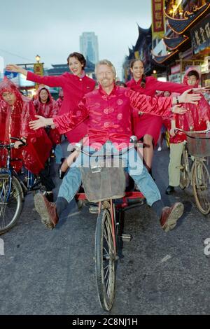 Sir Richard Branson, Gründer der Virgin Group, einschließlich Virgin Atlantic Airlines, radeln durch die Straßen von Shanghai und feiern im Juli 1999 den Erstflug der Fluggesellschaft von Heathrow in die chinesische Stadt. Stockfoto