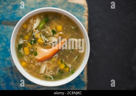 Eine hausgemachte Schale Krabbensuppe mit einer braunen Krabbe, Krebs Pagurus, die im Ärmelkanal gefangen wurde. Das Gericht enthält Frühlingszwiebeln, Süßungsmittel Stockfoto