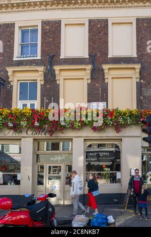 Das Straßenschild der Portobello Road prominent auf der Außenseite des Castle Pub, Notting Hill, London - dekoriert mit bunten Pflanzen. Stockfoto