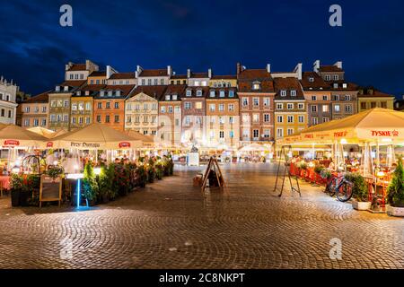 Warschau, Polen - 31. Mai 2019: Häuser und Tische im Freien auf dem Marktplatz der Altstadt bei Nacht im historischen Zentrum der Hauptstadt Stockfoto