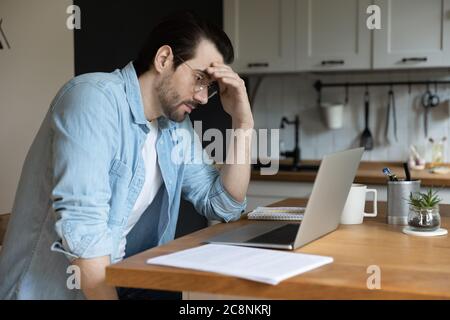 Nachdenkliche Mann Arbeit Blick auf Laptop-Bildschirm denken Stockfoto