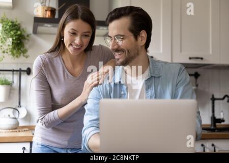 Lächelndes junges Paar hat Spaß mit Laptop Stockfoto