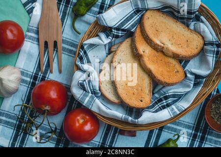 Natürliche frische Lebensmittel, italienische vegetarische Zutaten, Spaghetti mit Knoblauch und Brot Toast auf einem Korb auf Tischtuch, grüne Pfeffer Holzgabel Stockfoto