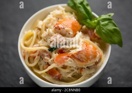 Eine Schüssel Krabbenlinguin mit dem weißen Fleisch von einer braunen Krabbe, Krebs Pagurus, die Sahne, Knoblauch, Basilikum, Chilis, Olivenöl und schwarz enthält Stockfoto