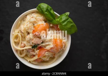 Eine Schüssel Krabbenlinguin mit dem weißen Fleisch von einer braunen Krabbe, Krebs Pagurus, die Sahne, Knoblauch, Basilikum, Chilis, Olivenöl und schwarz enthält Stockfoto