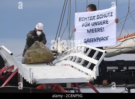 Sassnitz, Deutschland. Juli 2020. Greenpeace-Aktivisten versenken große Granitblöcke vom Greenpeace-Schiff "Beluga II" vor der Ostseeinsel Rügen ins Meer. Mit der Aktion im Adlergrund Meeresschutzgebiet wollen die Umweltschützer verhindern, dass der Boden von Fischern mit Schleppnetzen "durchgepflügt" wird. Quelle: Stefan Sauer/dpa/Alamy Live News Stockfoto