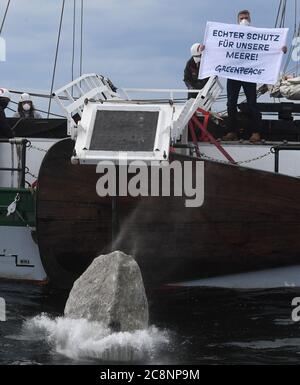 Sassnitz, Deutschland. Juli 2020. Greenpeace-Aktivisten versenken große Granitblöcke vom Greenpeace-Schiff "Beluga II" vor der Ostseeinsel Rügen ins Meer. Mit der Aktion im Adlergrund Meeresschutzgebiet wollen die Umweltschützer verhindern, dass der Boden von Fischern mit Schleppnetzen "durchgepflügt" wird. Quelle: Stefan Sauer/dpa/Alamy Live News Stockfoto