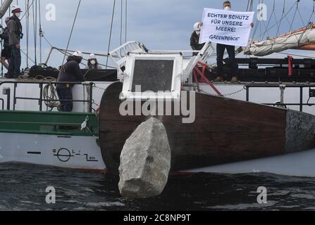 Sassnitz, Deutschland. Juli 2020. Greenpeace-Aktivisten versenken große Granitblöcke vom Greenpeace-Schiff "Beluga II" vor der Ostseeinsel Rügen ins Meer. Mit der Aktion im Adlergrund Meeresschutzgebiet wollen die Umweltschützer verhindern, dass der Boden von Fischern mit Schleppnetzen "durchgepflügt" wird. Quelle: Stefan Sauer/dpa/Alamy Live News Stockfoto