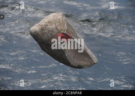 Sassnitz, Deutschland. Juli 2020. Ein Stein fällt in die Ostsee, während Greenpeace-Aktivisten des Greenpeace-Schiffes "Beluga II" vor der Insel Rügen große Granitblöcke ins Meer versenken. Mit der Aktion im Adlergrund Meeresschutzgebiet wollen die Umweltschützer verhindern, dass der Boden von Fischern mit Schleppnetzen "durchgepflügt" wird. Quelle: Stefan Sauer/dpa/Alamy Live News Stockfoto