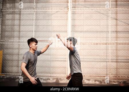 Zwei junge asiatische Athleten winken Fäuste feiern Erfolg Stockfoto