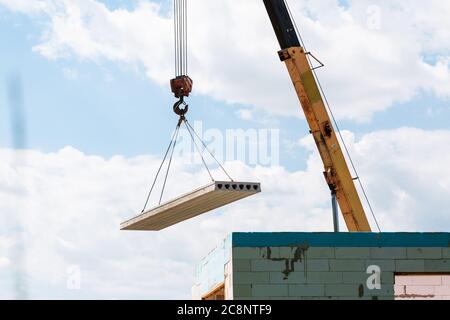 Bauarbeiter Montage Betonbodenplatte Platte auf der Baustelle. Zweite Etage Haus Beton Bodenplatte Installation Stockfoto