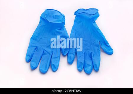 Paar medizinische blaue Latex Schutzhandschuhe auf weißem Hintergrund. Schutzhandschuhe gegen die Ausbreitung von Virus, Grippe, Coronavirus (COVID-19). Stockfoto