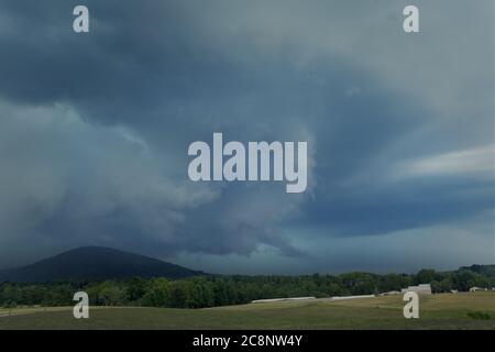 Ein intensives Sommergewitter ragt über einem Berg und einer Virginia Farm und bedroht die umliegende Landschaft. Stockfoto