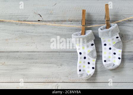 Baby Socken hängen auf Wäscheleine auf Holzhintergrund Stockfoto