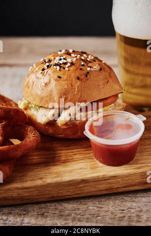 Ein Glas Bier und Snacks auf einem Holztisch auf dunklem Hintergrund Stockfoto