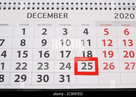 Weihnachtskonzept. Ein kleines rotes Quadrat umrahmt das Datum Dezember 25 im Kalender. Draufsicht Stockfoto