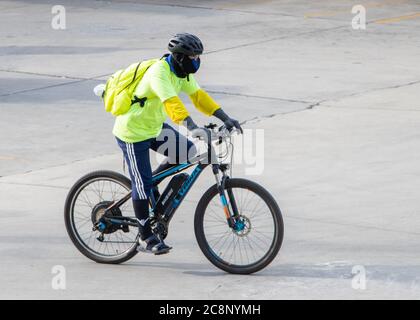 SAMUT PRAKAN, THAILAND, JULI 01 2020, EIN Mann in reflektierender Kleidung fährt ein elektrisches Fahrrad. Stockfoto