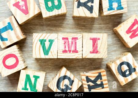 Buchstabenblock im Wort VMI (Abkürzung für Vendor Managed Inventory) mit einem anderen auf Holzhintergrund Stockfoto