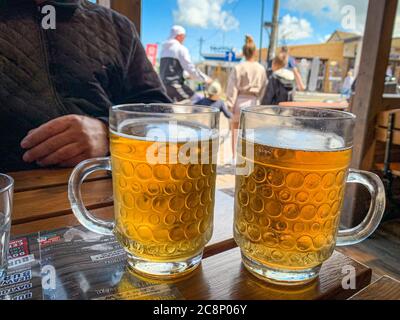 Auf einem Tisch stehen zwei große Gläser Bier nebeneinander Stockfoto