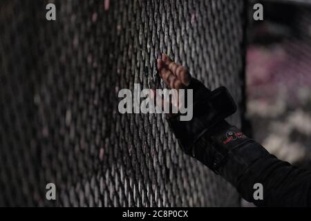 Portland, USA. Juli 2020. Ein Protestler hält die Hand gegen den Zaun, der am 25. Juli 2020 den Zugang zum Bundesgericht in Portland, Oregon, versperrt. (Foto: Alex Milan Tracy/Sipa USA) Quelle: SIPA USA/Alamy Live News Stockfoto