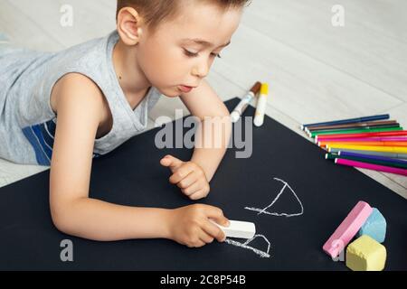 Vorschuljunge Schreiben Briefe. Nahaufnahme Kreide in der Hand des Kindes. Junge lernen, Briefe zu schreiben Stockfoto
