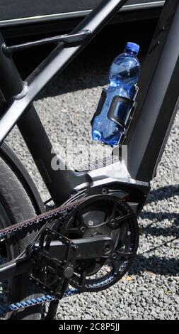 E-Bike Detail High Tech Carbon Fahrradkette und Getränkehalter mit blauer Wasserflasche Stockfoto