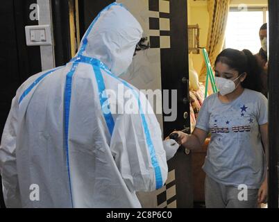 Mumbai, Indien. Juli 2020. Gesundheitshelfer, die einen Anzug für persönliche Schutzausrüstung (PSA) tragen, überprüft den Sauerstoffgehalt einer Frau, die eine Maske trägt.Indien berichtete in den letzten 24 Stunden über einen Anstieg von 48,661 Coronavirus-Fällen, sagte das Ministerium für Gesundheit und Familienwohlfahrt der Union heute. Die Gesamtzahl der Coronavirus-positiven Fälle liegt bei 13, 85,522. Kredit: SOPA Images Limited/Alamy Live Nachrichten Stockfoto