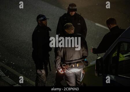 Polizisten warten während der Absperrung im Juli 2020 auf Handlungsanweisungen in einem Polizeiwagen Stockfoto