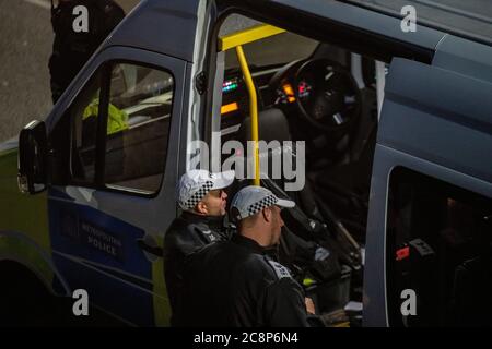 Polizisten warten während der Absperrung im Juli 2020 auf Handlungsanweisungen in einem Polizeiwagen Stockfoto