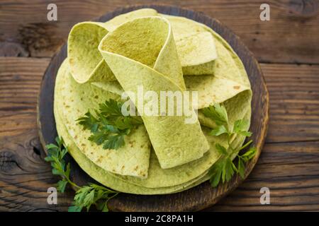 Grüne Spinattortilla auf dem Holztisch Stockfoto