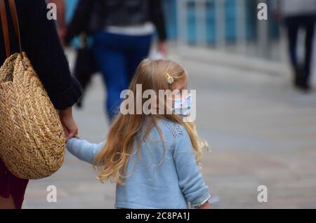 Ein kleines Mädchen im Alter von ca. 5 Jahren trägt eine Gesichtsmaske in der Öffentlichkeit in England nach einem Gesetz verabschiedet, die das Tragen von Gesichtsbedeckungen obligatorisch in Geschäften Stockfoto