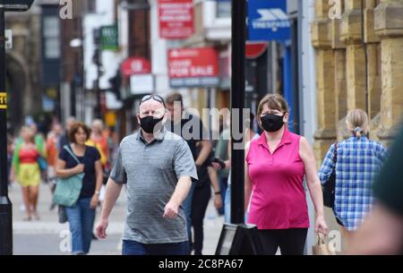 Ein übergewichtiger Mann und eine übergewichtige Frau tragen Gesichtsmasken in der Öffentlichkeit in England nach einem Gesetz verabschiedet, das das Tragen von Gesichtsbedeckungen obligatorisch in Geschäften Stockfoto