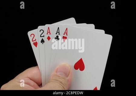 Hand hält Poker Spielkarten auf schwarzem Hintergrund. Stockfoto