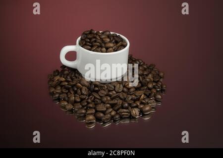 Papiertasse mit Kaffee und Kaffeebohnen auf rot Stockfoto