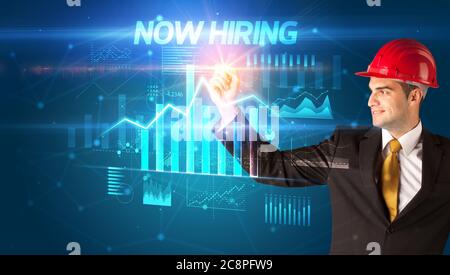 Gut aussehender Geschäftsmann mit Helm Zeichnung JETZT EINSTELLUNG Inschrift, Architektur Konzept Wipl Stockfoto