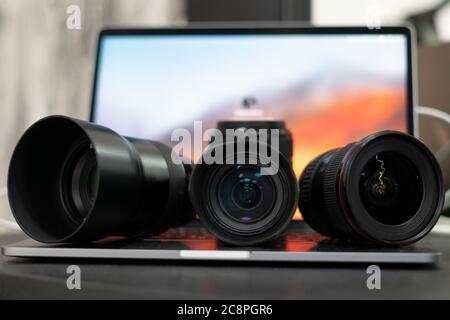 Ein Laptop und drei Objektive, ein Fotograf, der zu Hause arbeitet Stockfoto