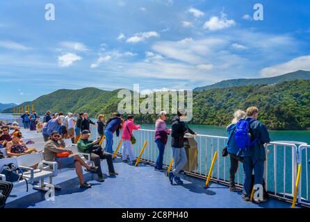 Passagiere, die die Marlborough Sounds vom Deck der Wellington-Fähre nach Picton, South Island, Neuseeland, betrachten Stockfoto