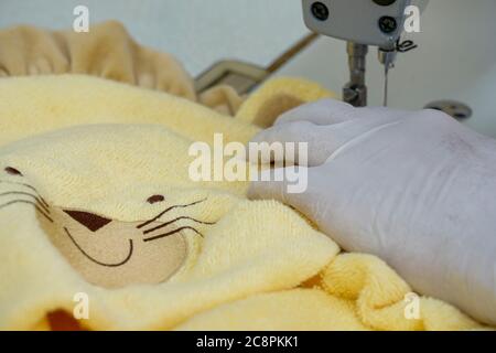 Hand in einen Handschuh in der Nähe der Nähmaschine Stockfoto