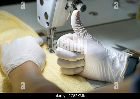 Hand in einen Handschuh in der Nähe der Nähmaschine Stockfoto