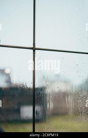 Fensteransicht bei bewölktem Wetter - Regentropfen auf Glas - verschwommener Hintergrund Stockfoto