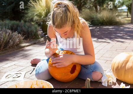 11-jähriges Mädchen, das einen Kürbis schnitzt Stockfoto