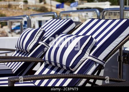 Luxuriöse Yacht-Liegen. Isoliert. Blau und weiß gestreifte Liegen auf Deck der Yacht. Fokus im Vordergrund. Bild auf Lager. Stockfoto