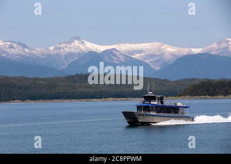 Juneau, Alaska. USA - 24. Juli 2018. Whale Watching Boot auf der Suche nach Buckelwalen in Auke Bay mit Schneeberg im Hintergrund, Alaska Stockfoto