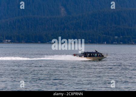 Juneau, Alaska. USA - 24. Juli 2018. Whale Watching Boot auf der Suche nach Buckelwalen in Auke Bay mit Berg im Hintergrund, Alaska Stockfoto