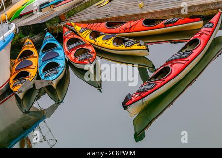 Bunte Kajaks stehen auf dem Pier mit ruhigem Wasser auf Ketchikan, Alaska, USA Stockfoto