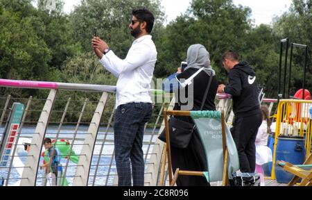 Northampton, Großbritannien. Juli 2020. Selfie-Zeit auf der Promenade mit Blick auf den See die Menschen genießen den warmen Sonntagnachmittag im Rushden Lakes Shopping and Leisure Complex in der Nähe von Northampton, Großbritannien am Sonntag, dem 26. Juli 2020 Credit: KEITH MAYHEW/Alamy Live News Stockfoto